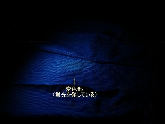 前記ズボンにブラックライトを当てている写真。チャック部で発光している